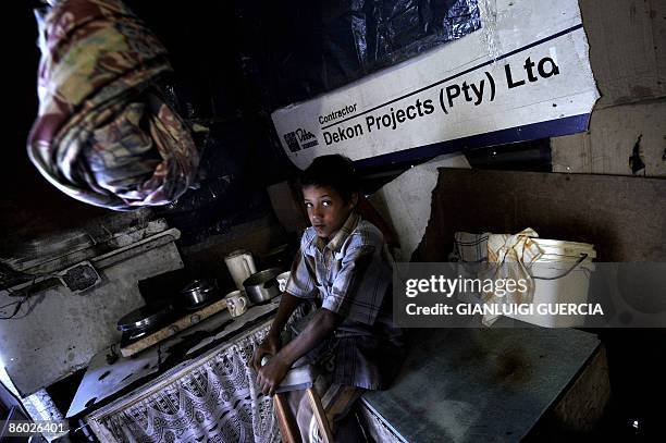 Young South African boy sits with his crutches on a furnitures on April 15, 2009 inside his mother's house at the Tafelsig township in Mitchells...