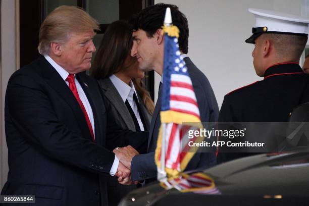 President Donald Trump shakes hands with Canadian Prime Minister Justin Trudeau as First Lady Melania Trump looks on following their meeting at the...