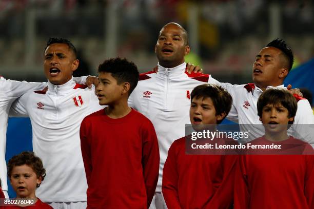 Alberto Rodriguez, Yoshimar Yotun and Christian Cueva of Peru sing the national anthem during match between Peru and Colombia as part of FIFA 2018...