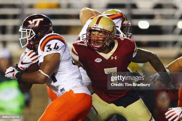 Harold Landry of the Boston College Eagles attempts to tackle Travon McMillian of the Virginia Tech Hokies at Alumni Stadium on October 7, 2017 in...