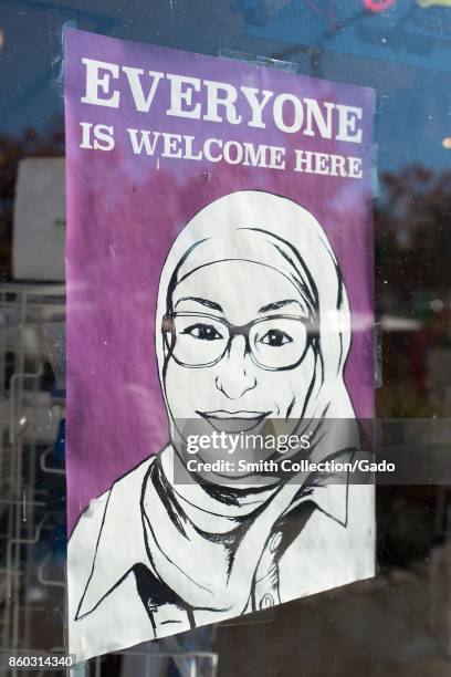 Sign in a store window in the Gourmet Ghetto neighborhood of Berkeley, California reading "Everyone is Welcome Here" and featuring an image of a...