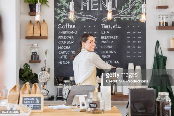 female barista looks over her shoulder - menu stock pictures, royalty-free photos & images