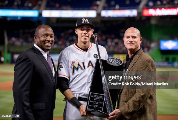 Christian Yelich of the Miami Marlins is presented the Silver Slugger award from Michael Hill before the Opening Day game against the Atlanta Braves...