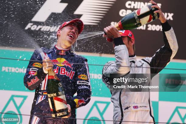 Race winner Sebastian Vettel of Germany and Red Bull Racing celebrates with third placed Jenson Button of Great Britain and Brawn GP on the podium...