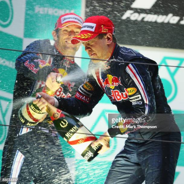 Race winner Sebastian Vettel of Germany and Red Bull Racing celebrates with second placed team mate Mark Webber of Australia and Red Bull Racing on...