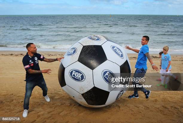 Melbourne City player Tim Cahill and Melbourne Victory's Archie Thompson play a game of beach soccer with kids from Melbourne City and Melbourne...