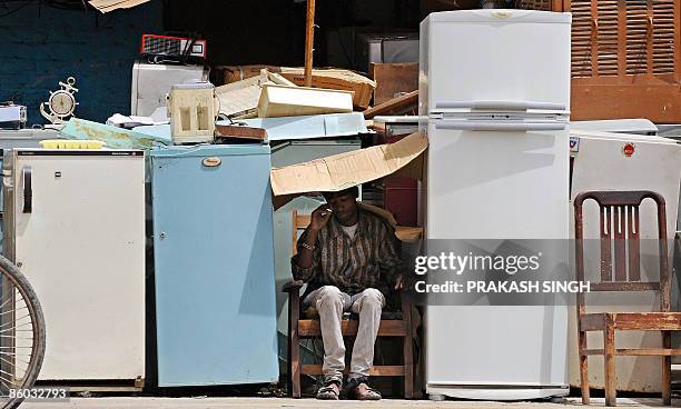 Shopkeeper takes a nap as he waits for customers for used refrigerators and other household items in New Delhi on April 19, 2009. India's inflation...