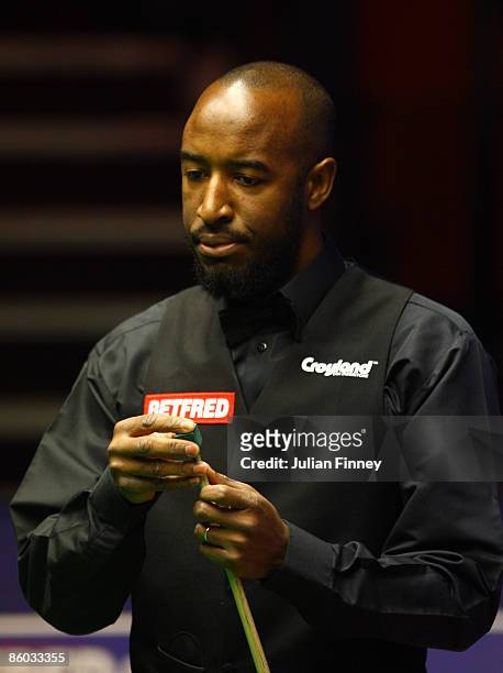 Rory McLeod of England chalks his cue in his first round match against Mark King of England during the Betfred World Snooker Championships at the...