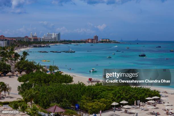 toeristische resort van palm beach in aruba op de zuid-caribische zee in de ochtendzon. verschillende luxe beach hotels en boten op anker offshore. - palm beach aruba stockfoto's en -beelden