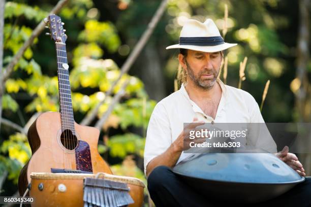 en man spela en handpan och sjunga i skogen - ståltrumma bildbanksfoton och bilder