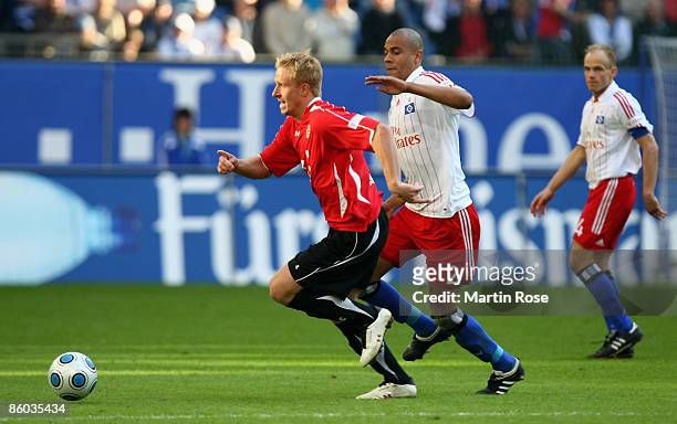 Alex Silva of Hamburg and Mike Hanke of Hannover run for the ball during the Bundesliga match between Hamburger SV and Hannover 96 at the HSH...