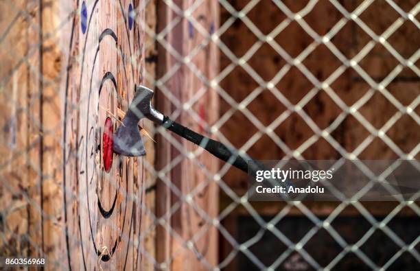 An axe is seen towards a target at the facility of an indoor axe throwing company, Bad Axe Throwing, in Chicago, United States on October 12, 2017....