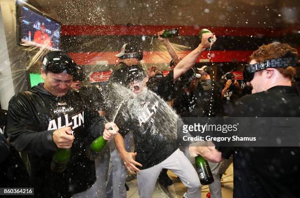Masahiro Tanaka of the New York Yankees and teammates celebrate in the locker room after their 5 to 2 win over the Cleveland Indians in Game Five of...