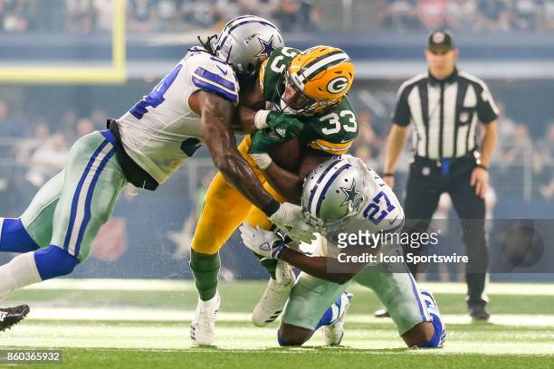 Green Bay Packers running back Aaron Jones is tackled by Dallas Cowboys outside linebacker Jaylon Smith and cornerback Jourdan Lewis during the...