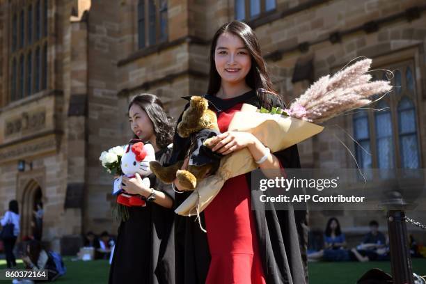 Student Zheng Zizan from Xian in China poses for family photos after graduating with a Masters of Commerce from Sydney University on October 12,...