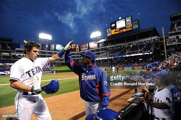 Ian Kinsler of the Texas Rangers celebrates a solo homerun with manager Ron Washington while wearing jersey to commemorate Jackie Robinson day during...