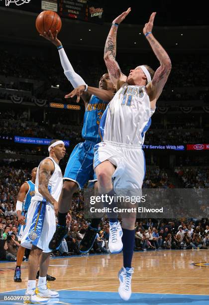 Chris Paul of the New Orleans Hornets goes to the basket against Chris Andersen of the Denver Nuggets during Game One of the Western Conference...