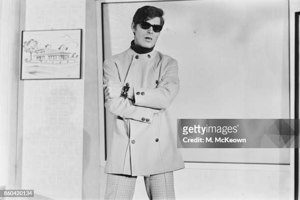 Fashion model wearing a short double-breasted buttoned coat designed by British fashion designer Tom Gilbey , 10th March 1967.