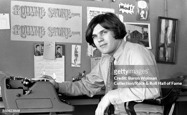 Portrait of Jann Wenner, founder and publisher of Rolling Stone magazine, sitting at a typewriter in the magazine's original offices on Brannan St in...
