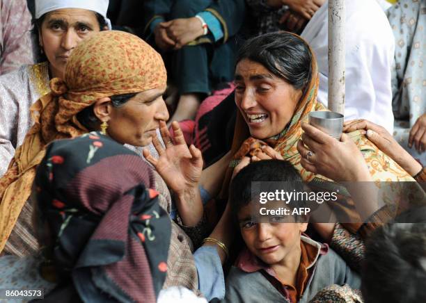 Kashmiri Muslims and relatives of rebel commander Abdul Rashid Baigh wail outside his home at Ganesthanpora some 32 km north of Srinagar on April 20,...