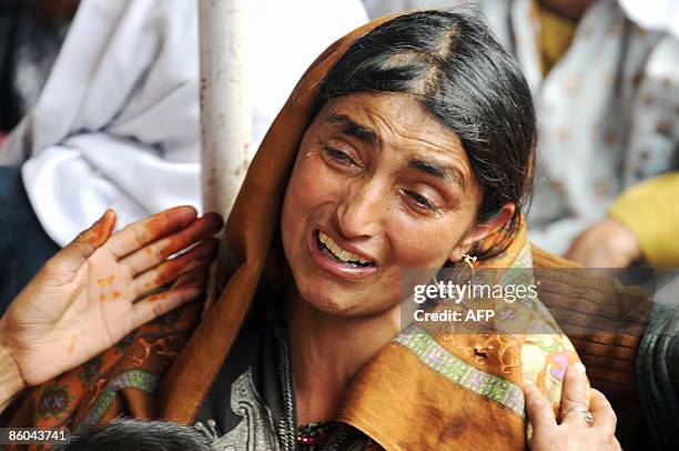 Relative of Kashmiri Muslim rebel commander Abdul Rashid Baigh wails outside his home at Ganesthanpora some 32 km north of Srinagar on April 20,...