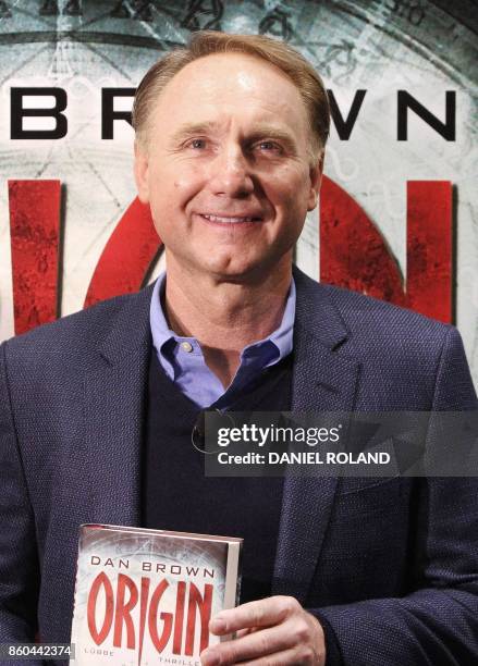 Author Dan Brown poses in front of a poster promoting his new book "Origin" at the Frankfurt Book Fair 2017 in Frankfurt am Main, western Germany, on...