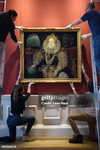 Gallery assistants pose with the "Armada Portrait of Elizabeth I" oil painting as it is unveiled following extensive cleaning at the Queen's House,...