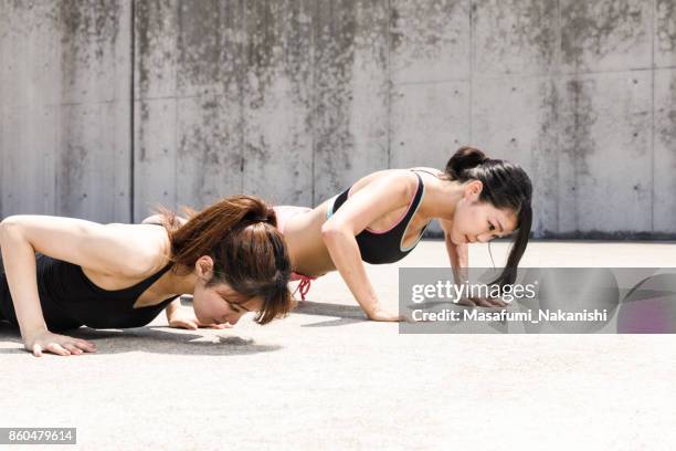 zwei sportliche japanerinnen sind einen harten training im freien tun. - push up japanese stock-fotos und bilder