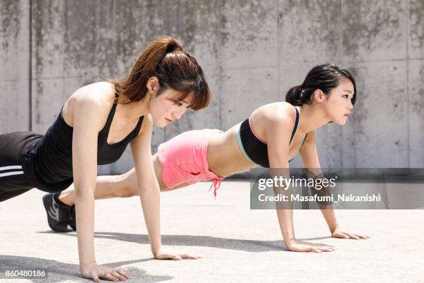 zwei sportliche japanerinnen sind einen harten training im freien tun. - push up japanese stock-fotos und bilder