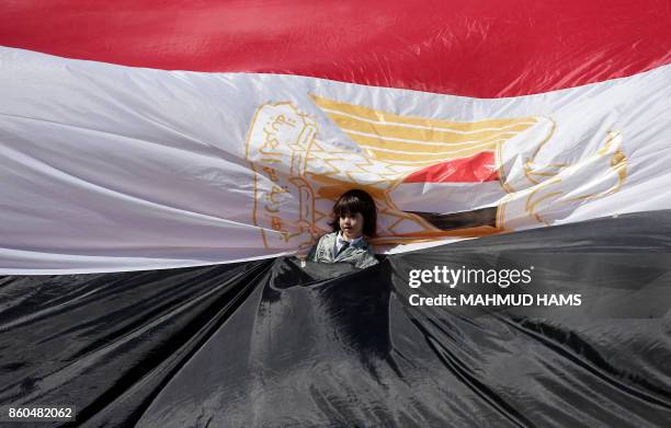 Young girl stands wrapped in an Egyptian flag as Palestinians gather in Gaza City to celebrate after rival Palestinian factions Hamas and Fatah...