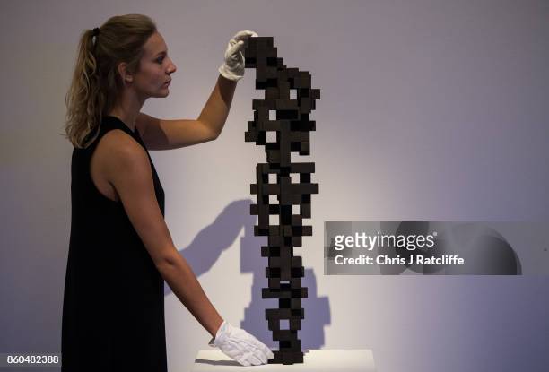 Sotheby's art handler poses for photographs next to Small Charge by Anthony Gormley, estimated at £120,000-£180 during an Art for Grenfell press call...