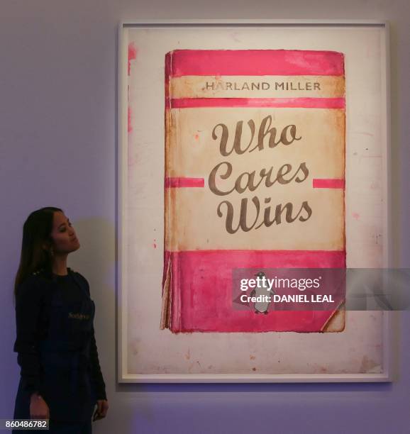 Gallery employee poses in front of artworks entitled 'Who Cares Wins' 2017 by British artist Harland Miller during a photocall for the "Art For...