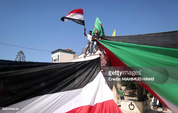 Palestinians wave the flags of Egypt and Palestine as they gather in Gaza City to celebrate after rival Palestinian factions Hamas and Fatah reached...