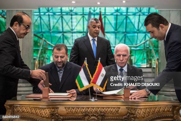 Fatah's Azzam al-Ahmad and Saleh al-Aruri of Hamas sign a reconciliation deal at the Egyptian intelligence services headquarters in Cairo on October...