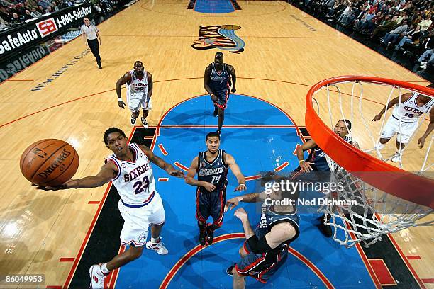 Louis Williams of the Philadelphia 76ers lays the ball up over D.J. Augustin and Vladimir Radmanovic of the Charlotte Bobcats during a game on March...