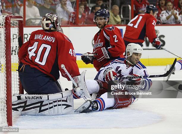 Scott Gomez of the New York Rangers is stopped by Simeon Varlamov and Brian Pothier of the Washington Capitals during Game Two of the Eastern...