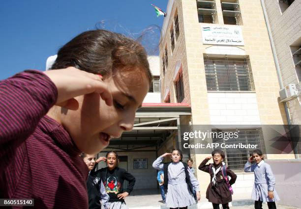 Palestinian girls play at the Dalal al-Mughrabi elementary school on October 12 in the village of Beit Awwa, west of the West Bank town of Hebron....