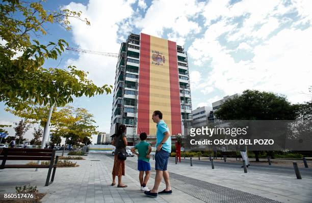 Huge Spanish flag covers the facade of building under construction in Valdebebas neighborhood in Madrid, October 12, 2017. - Spain marks its national...