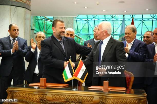 Palestinian Fatah movement leader Azzam Al-Ahmad and Deputy Chairman of the Movement's Political Bureau Saleh Al-Arouri shake hands after signing the...