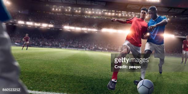 rival soccer players in challenge for possession of football - tackling stock pictures, royalty-free photos & images
