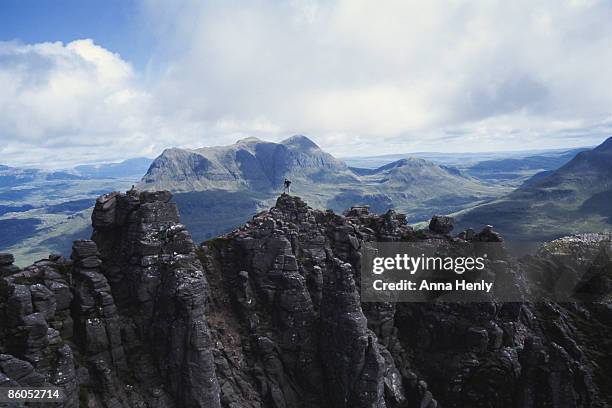 person on jagged mountain peak, scotland - stac pollaidh foto e immagini stock