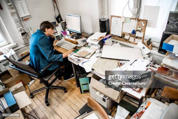 high angle view of office worker working on computer - cluttered stock pictures, royalty-free photos & images