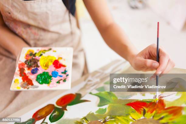 female artist working in studio - easel imagens e fotografias de stock