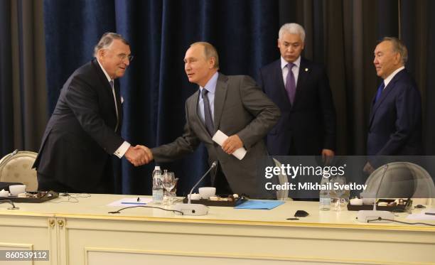 Russian President Vladimir Putin greets German businessman, CEO of TUI AG Klaus Mangold as Kazakh President Nursultan Nazarbayev looks on during...