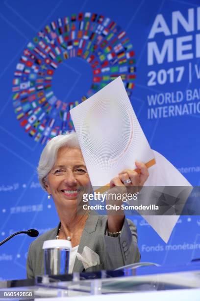International Monetary Fund Managing Director Christine Lagarde holds up a copy of the IMF Global Policy Agenda during the opening news conference of...