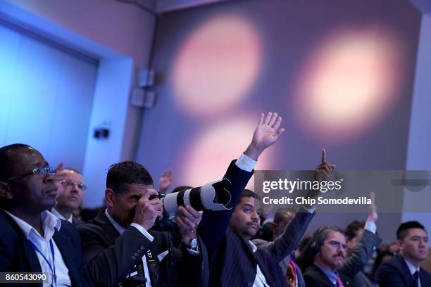 Journalists raise their hands to ask questions of International Monetary Fund Managing Director Christine Lagarde during the opening news conference...