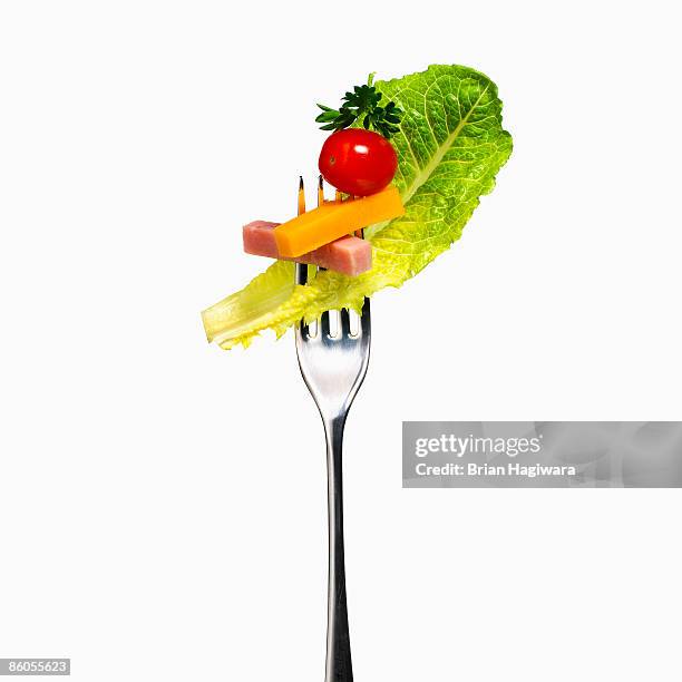 chef salad on a fork - tafelbesteck stock-fotos und bilder