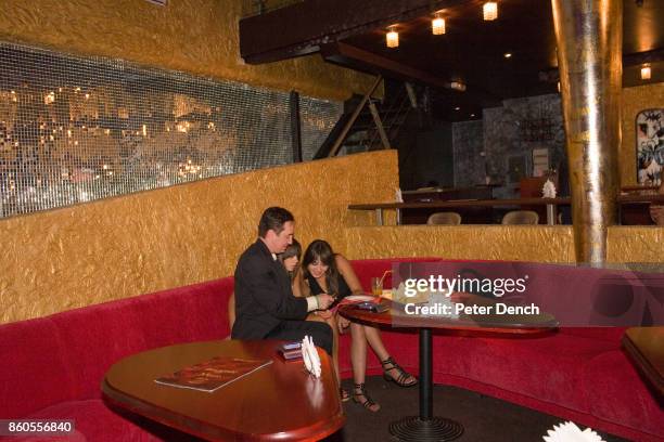 Craig talks to two young women at a social event organised by The Anastasiaweb.com Experience at The Palladium Club, Odessa, where he hopes to meet a...