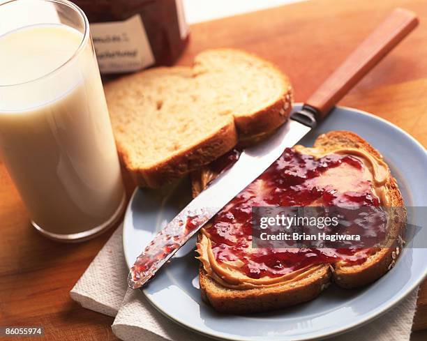 peanut butter and jelly sandwich with glass of milk - preserves stockfoto's en -beelden