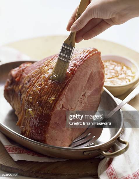 glazing spiral-cut ham - spiral ham stock pictures, royalty-free photos & images